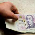 Uomo che preleva contante da un bancomat, con focus sulla soglia mensile per il controllo fiscale.