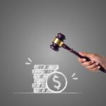 Immagine di una casa all'asta con cartello "Vendita" e persone interessate in primo piano.